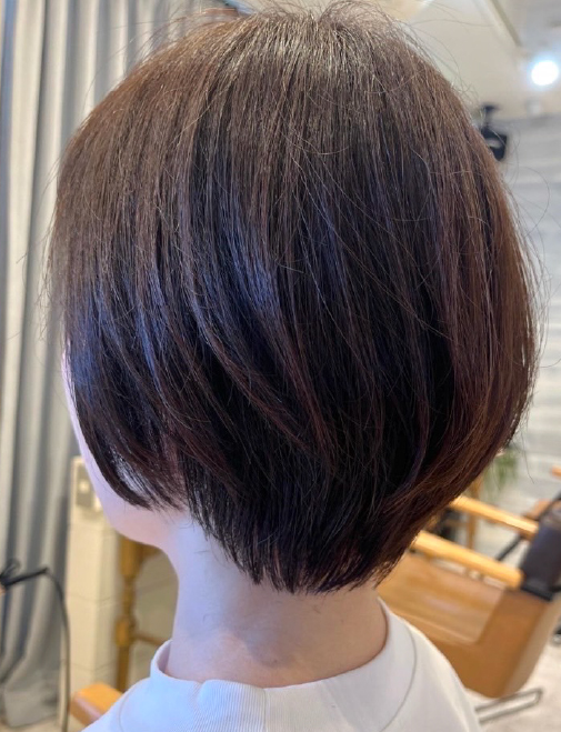 首元がすっきり見える丸みのあるショートボブにカットされたアフターのスタイル。髪にツヤとまとまりが出て、軽やかな印象に仕上がっている。