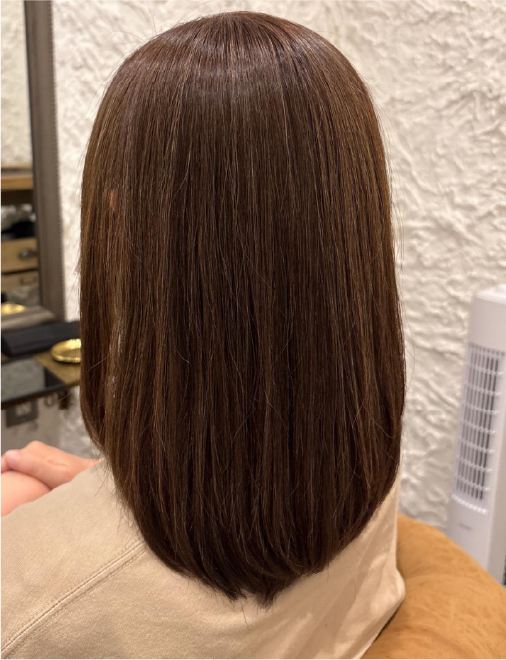 艶のあるストレートヘアに整えられた落ち着いたブラウンカラーの髪。